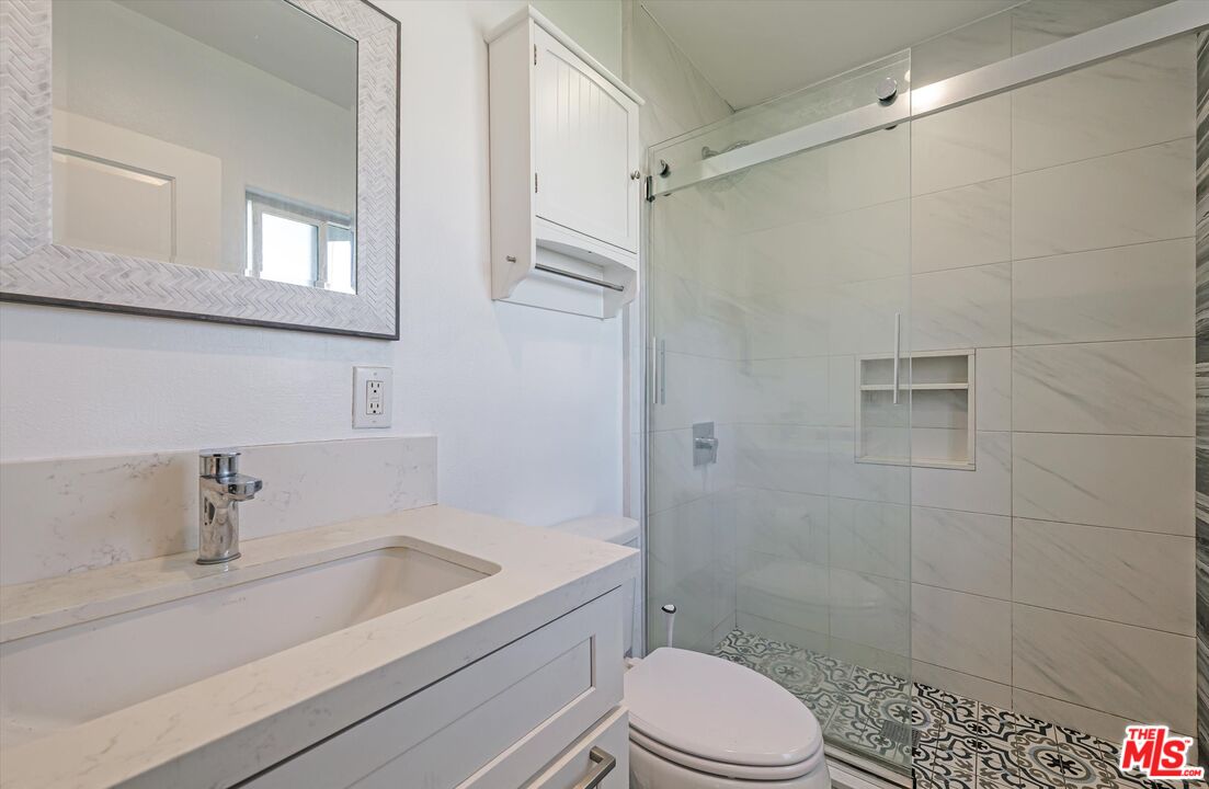 3447 9th Avenue Los Angeles, CA 90018 - Photo 10 of 18 a bathroom with a sink a toilet and shower