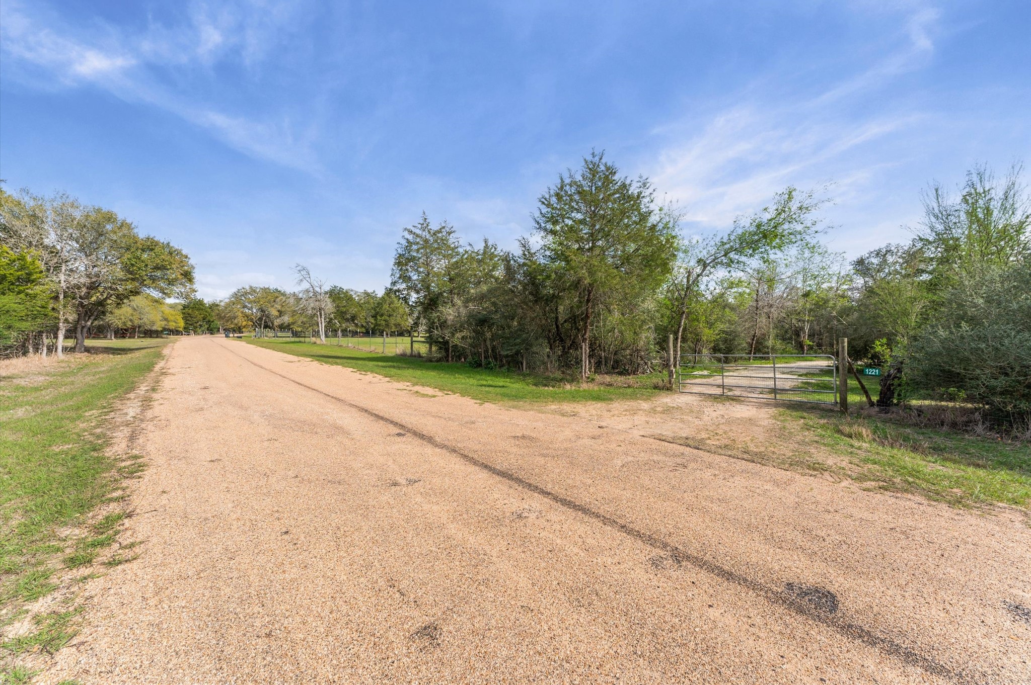 1221 Abel Road New Ulm, TX 78950 - Photo 14 of 15 A gated entrance leads to a private property, offering a peaceful and quiet atmosphere. Perfect for nature lovers seeking tranquility.