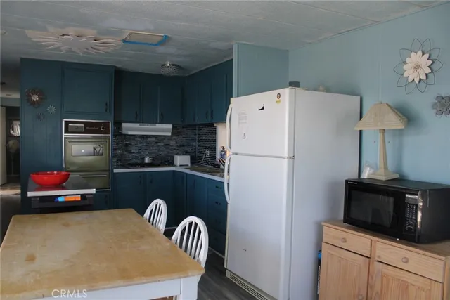 a kitchen with a refrigerator and a stove