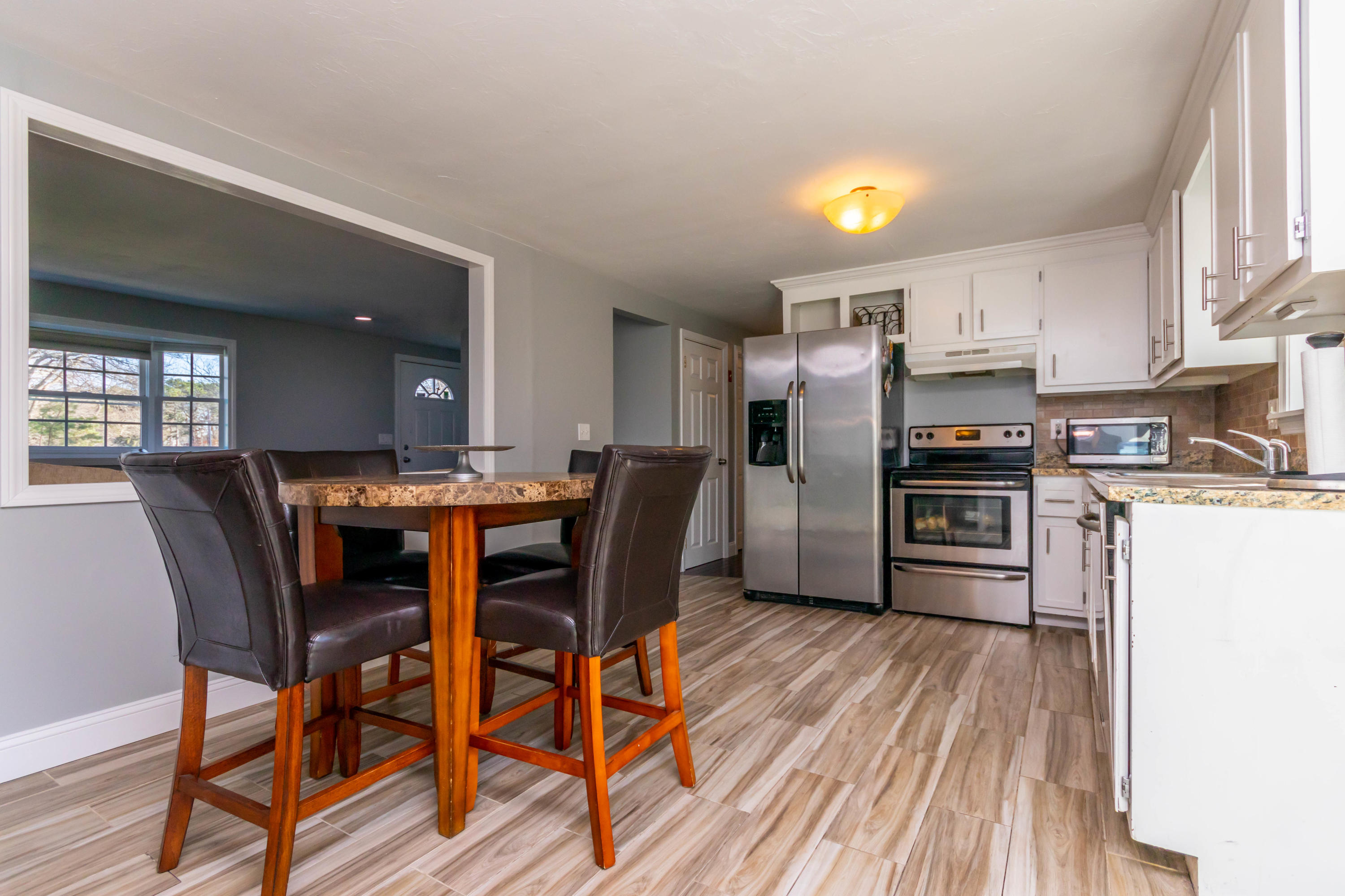 371 Megan Road Hyannis, MA 02601 - Photo 7 of 34 a kitchen with stainless steel appliances a dining table chairs and wooden floor
