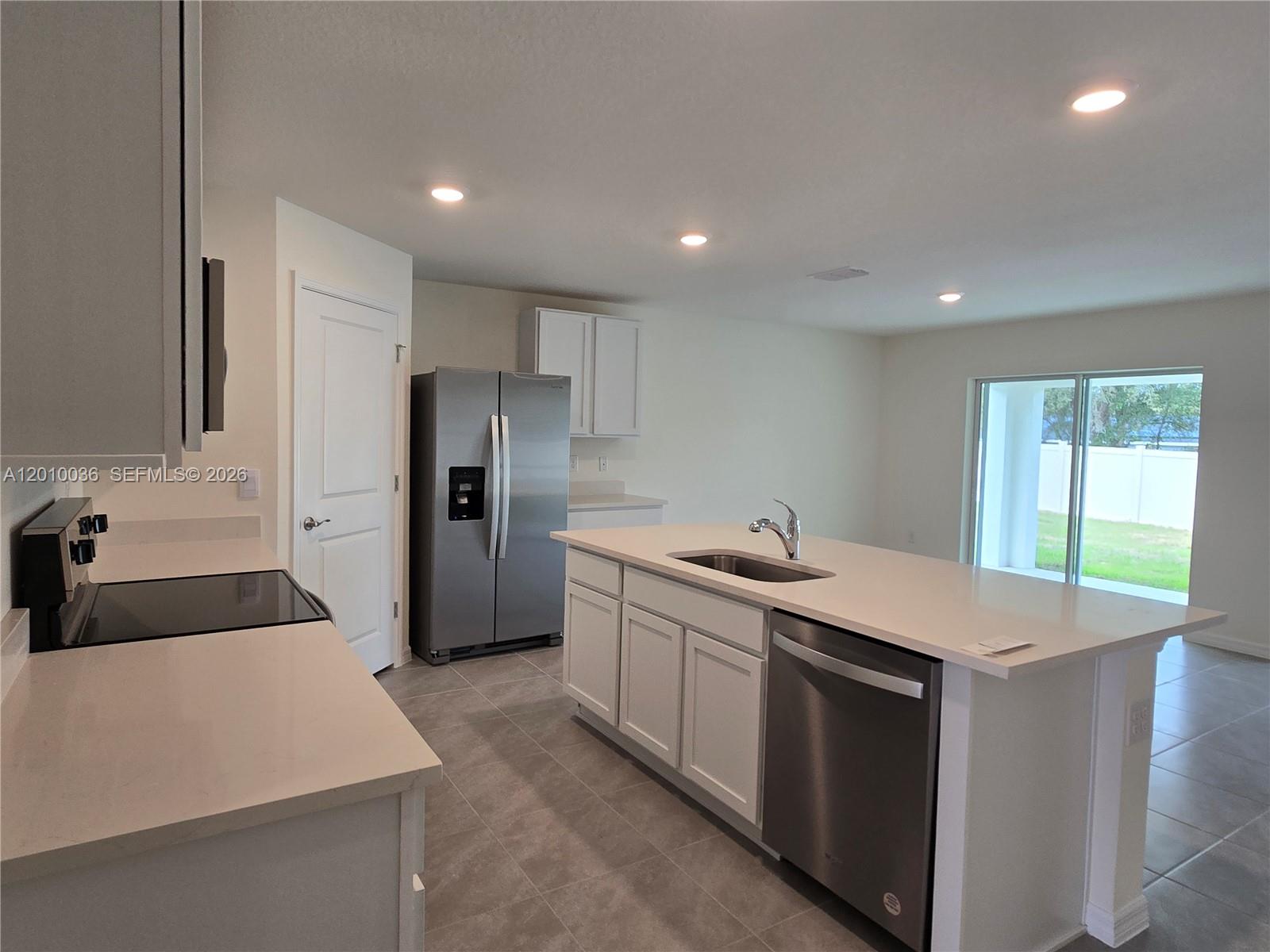 9871 Southeast 161st Lane Road Summerfield, FL 34491 - Photo 4 of 31 a kitchen that has a sink a stove and a refrigerator