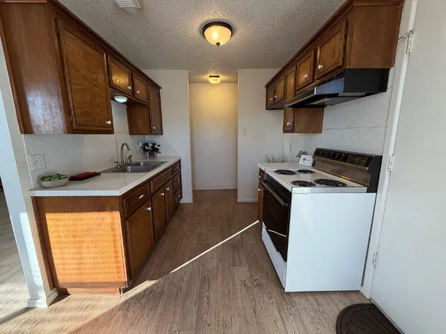 a kitchen with stainless steel appliances granite countertop a stove a sink and a refrigerator