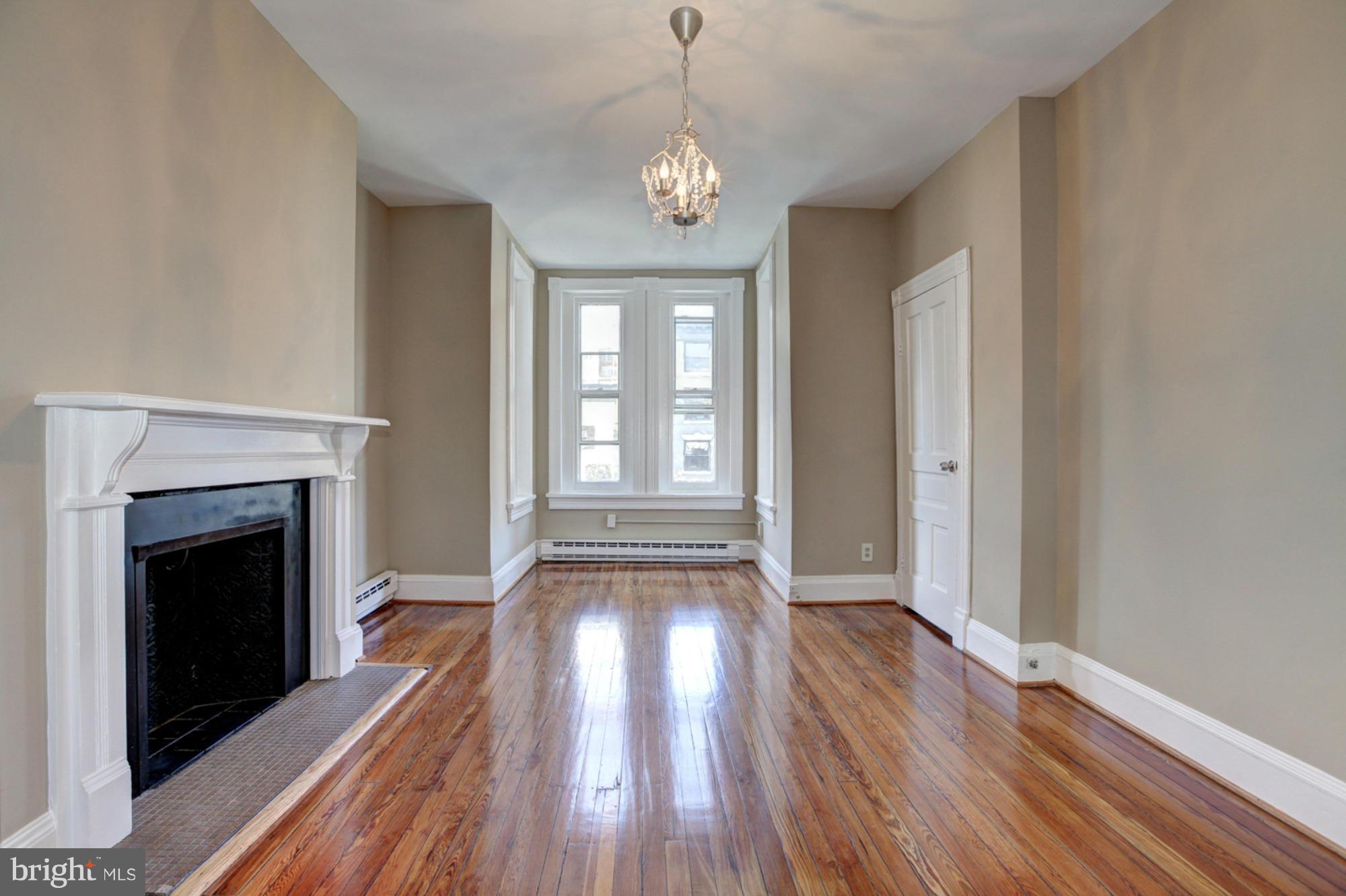 1739 19th Street Northwest Washington, DC 20009 - Photo 5 of 20 a view of an empty room with wooden floor fireplace and a window