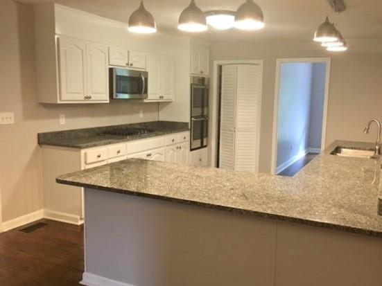 316 Lower Simmons Road Macon, GA 31220 - Photo 8 of 34 a kitchen with stainless steel appliances granite countertop a sink a stove and a microwave