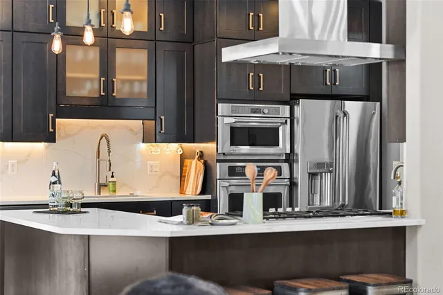 a kitchen with stainless steel appliances a dining table chairs stove and white cabinets