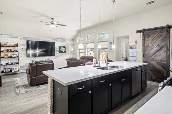 a kitchen with stainless steel appliances a sink a stove top oven a counter space and cabinets