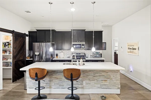 a kitchen with stainless steel appliances granite countertop a stove a sink and a refrigerator