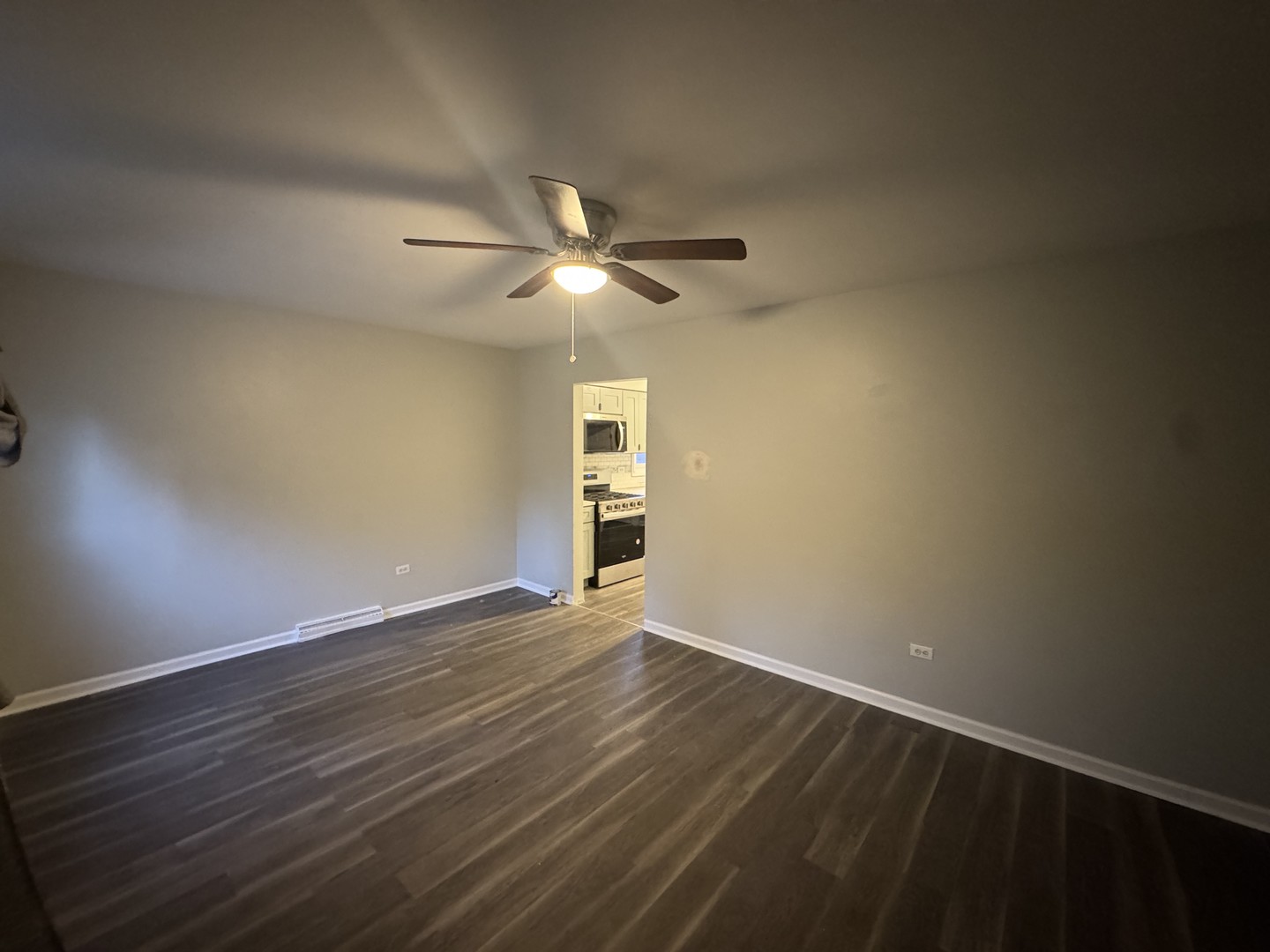 1447 West 114th Place Chicago, IL 60643 - Photo 3 of 21 a view of an empty room with a window and wooden floor