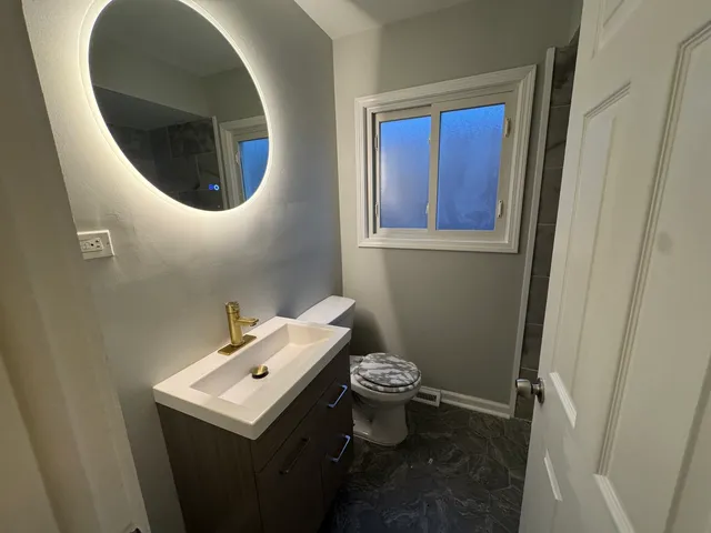 a bathroom with a sink toilet and mirror