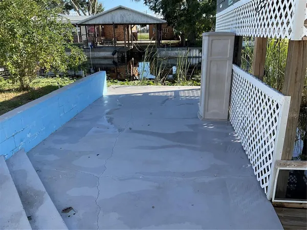 a view of a patio with chairs and wooden fence