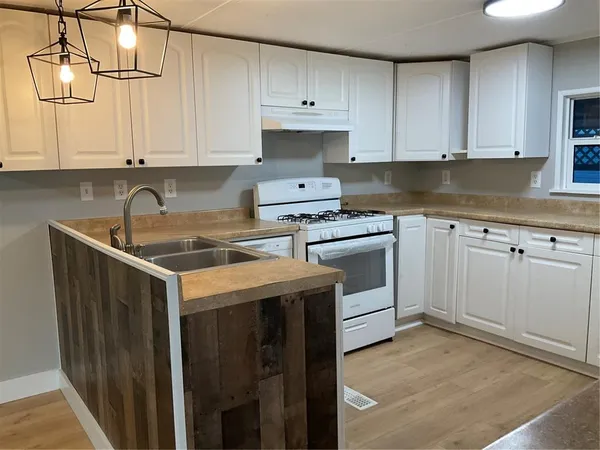 a kitchen with white cabinets sink and stove