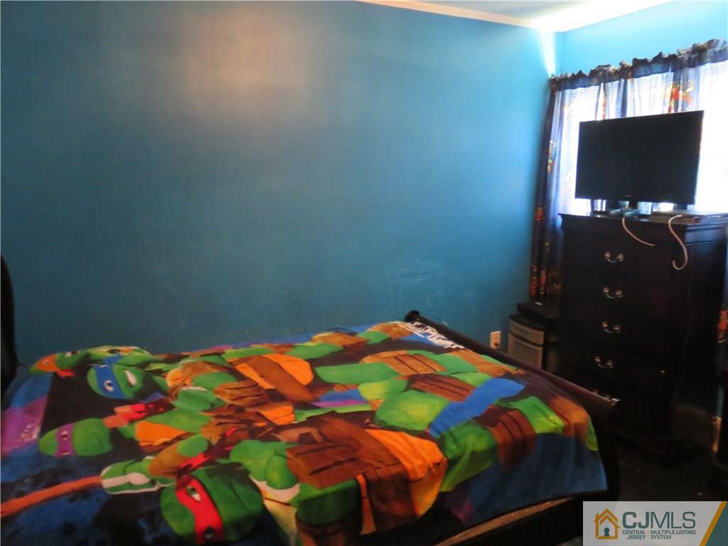 12 Pennington Road New Brunswick, NJ 08901 - Photo 6 of 10 a bedroom with a bed and a flat screen tv