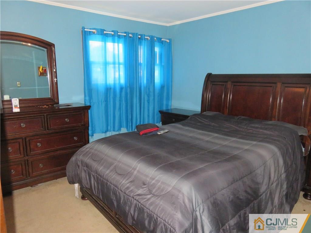 12 Pennington Road New Brunswick, NJ 08901 - Photo 7 of 10 a bedroom with a bed and a dresser