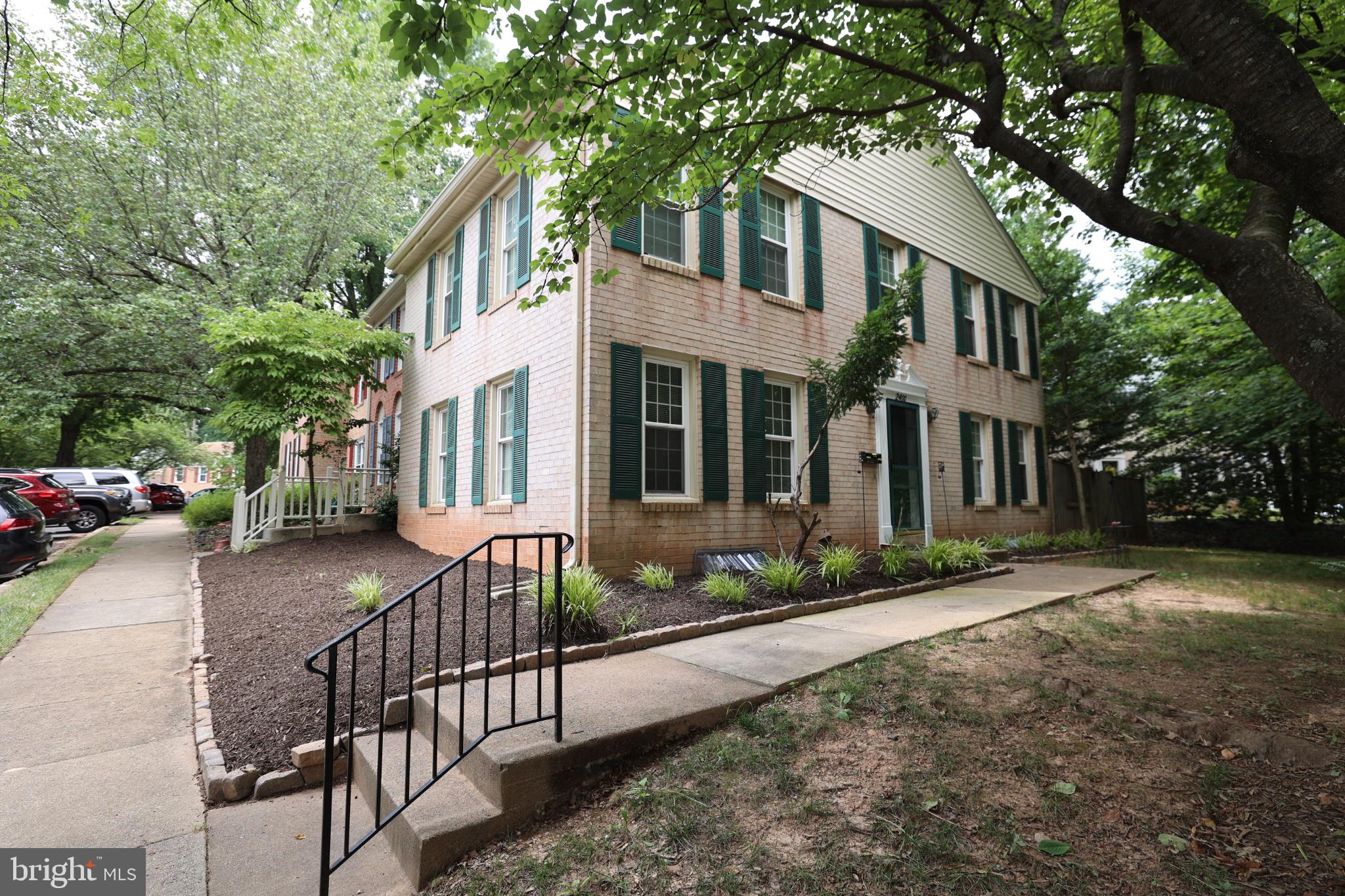 Charming brick duplex with lush greenery.