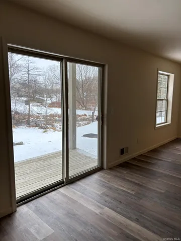 a view of an empty room with wooden floor and doors