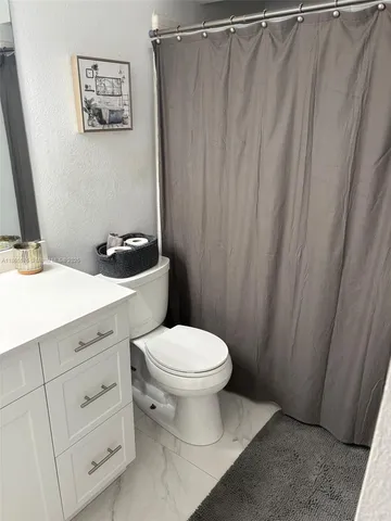 a white toilet sitting next to a bathroom sink