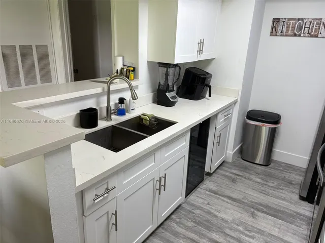 a kitchen with a sink and a stove next to a white refrigerator