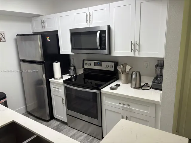 a kitchen with stainless steel appliances a stove microwave and refrigerator