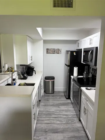 a kitchen with stainless steel appliances granite countertop a sink and stove top oven