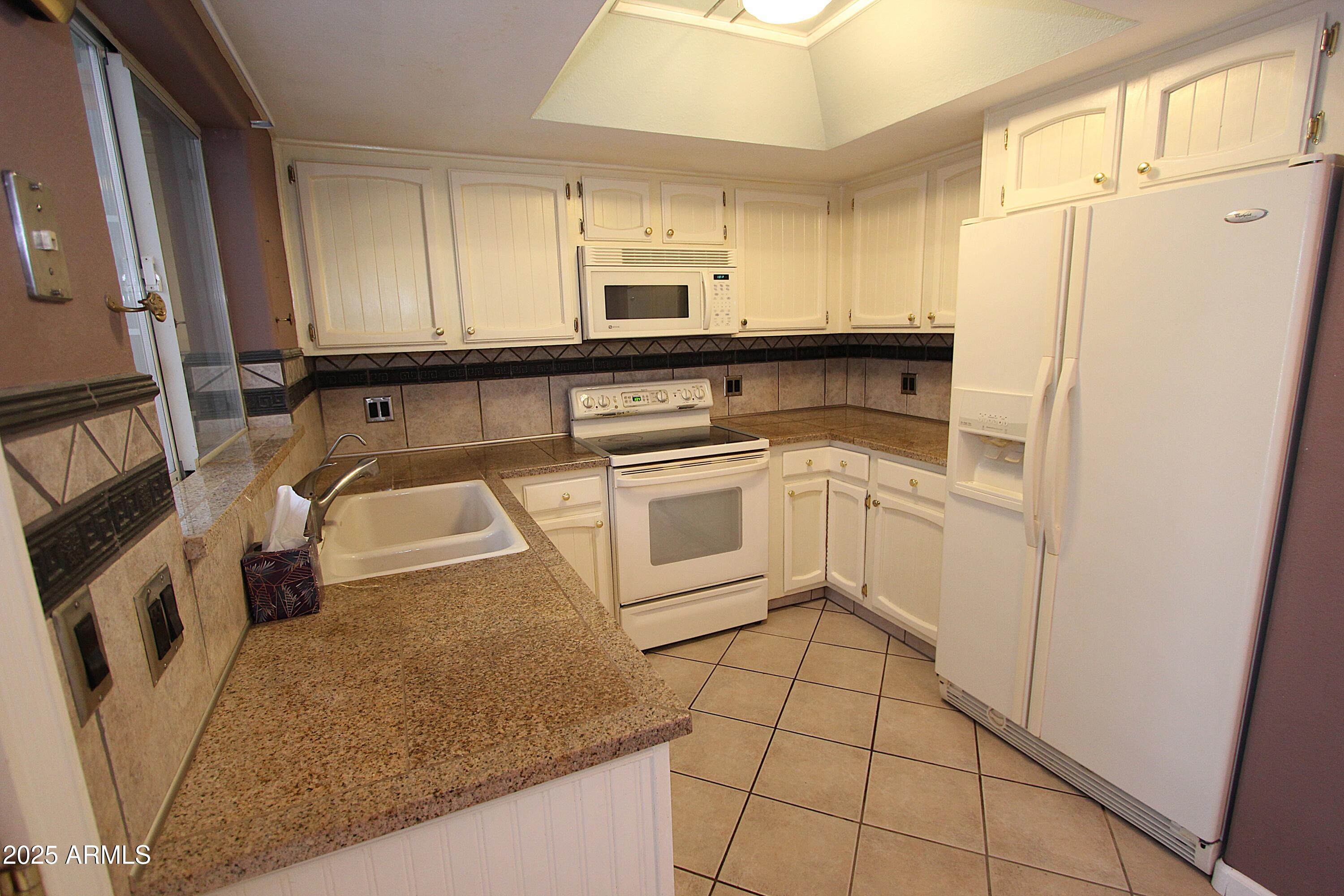 10411 North 11th Avenue, Unit 3 Phoenix, AZ 85021 - Photo 7 of 23 a kitchen with stainless steel appliances granite countertop a sink stove and refrigerator