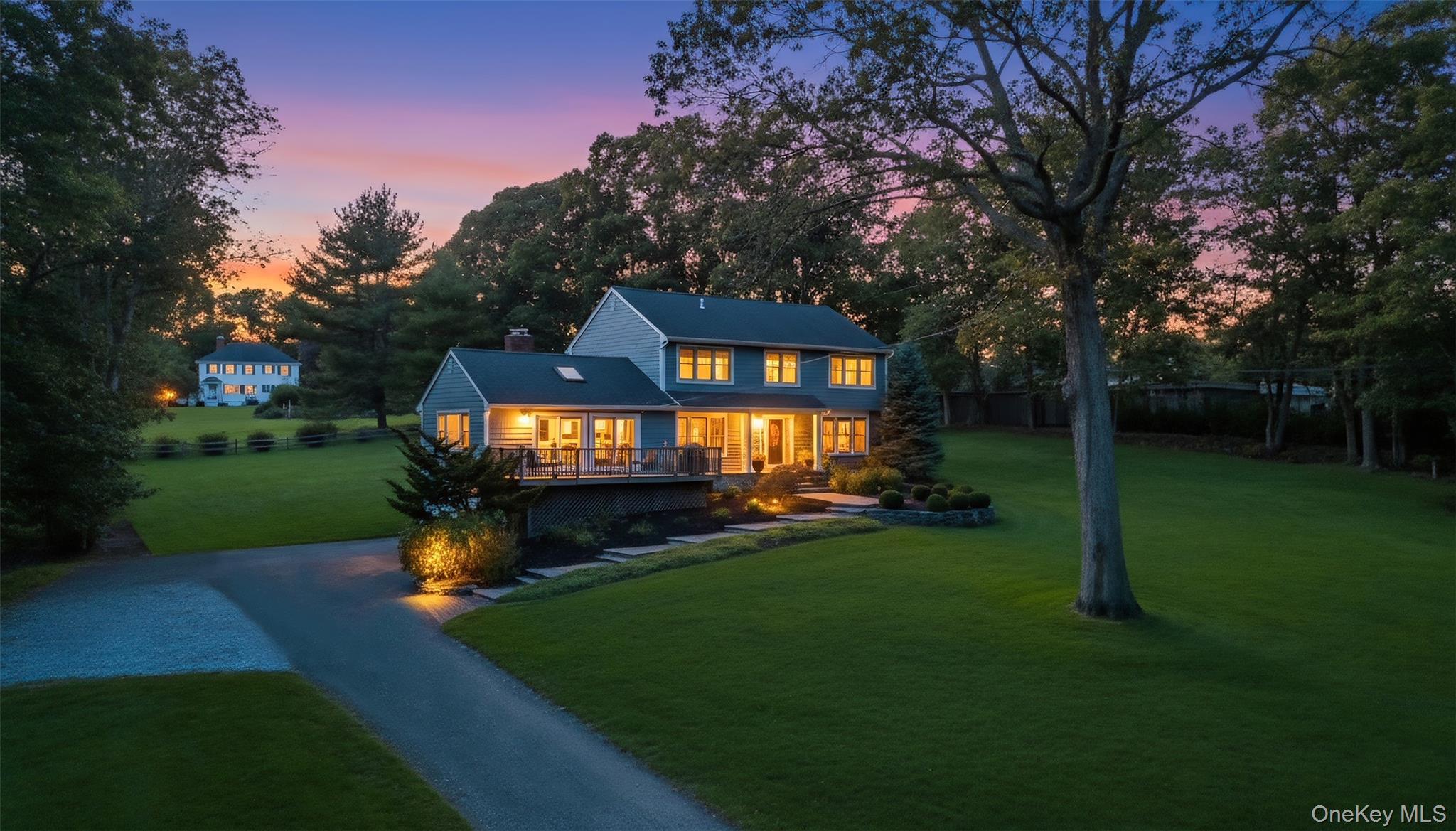 39 Bevin Road Northport, NY 11768 - Photo 4 of 44 Back of house at dusk with a lawn, a chimney, and driveway