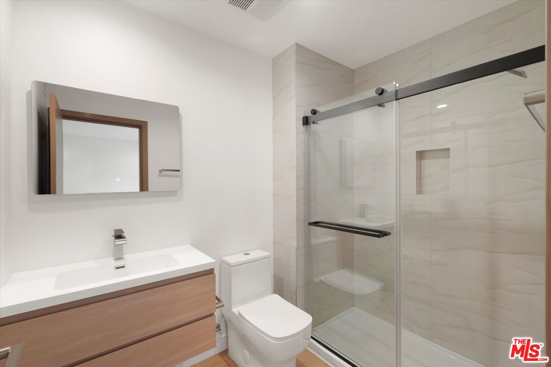 11025 1/2 Blix Street North Hollywood, CA 91602 - Photo 15 of 18 a bathroom with a toilet a sink and a shower