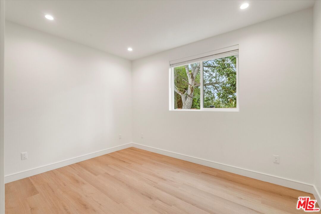 11025 1/2 Blix Street North Hollywood, CA 91602 - Photo 16 of 18 an empty room with wooden floor and windows