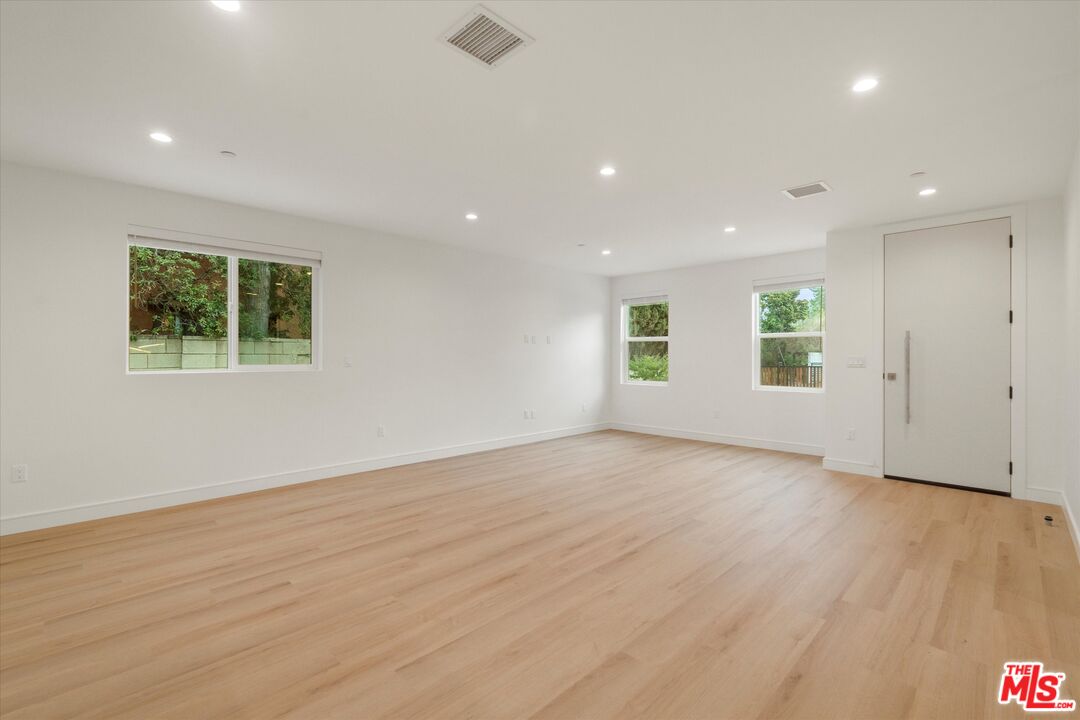 11025 1/2 Blix Street North Hollywood, CA 91602 - Photo 7 of 18 an empty room with wooden floor and windows