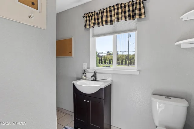 a bathroom with a sink a toilet and a window