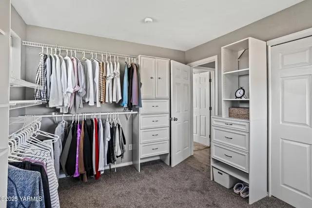 a view of walk in closet with clothes and shoes