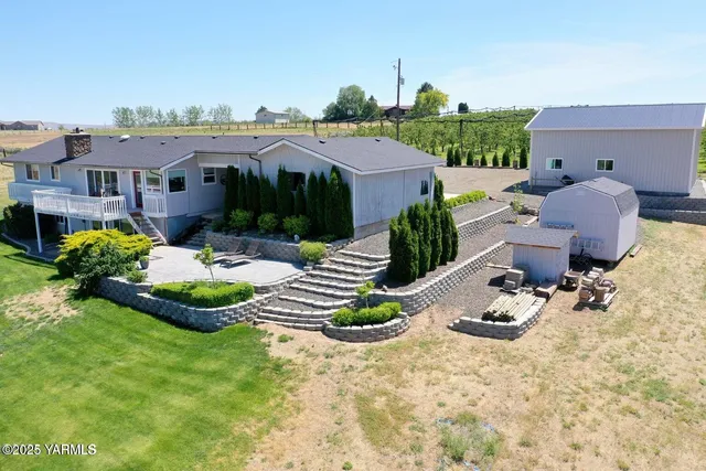 a view of a house with backyard and sitting area