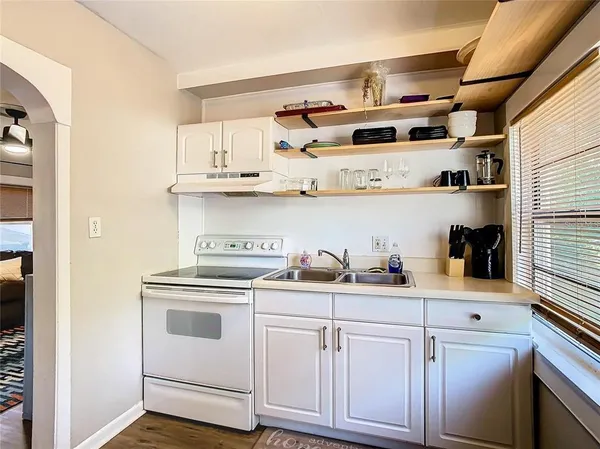 a kitchen with white cabinets and white appliances
