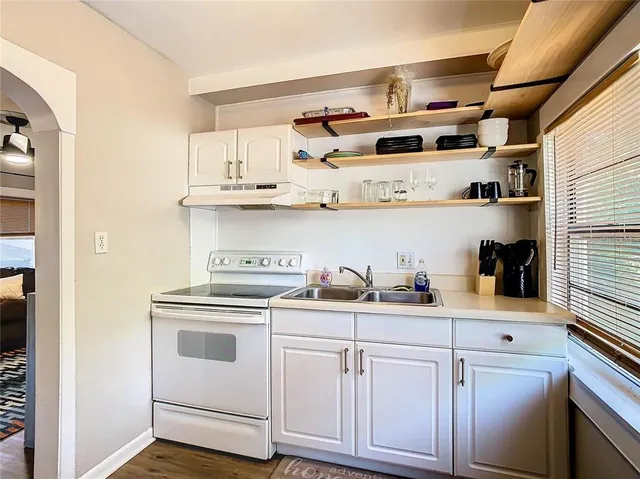 a kitchen with white cabinets and white appliances