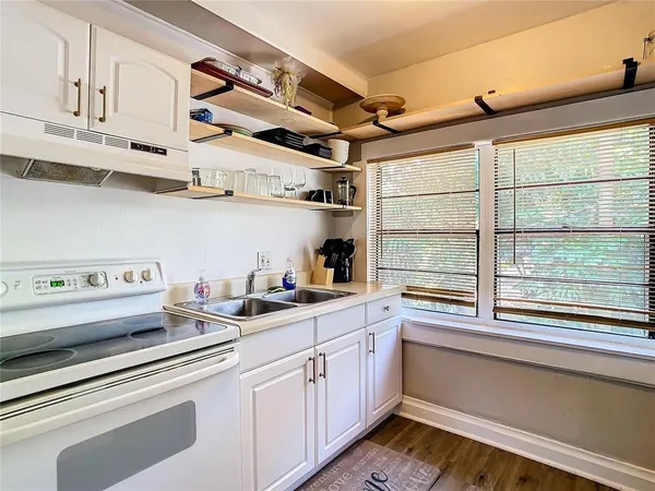 a kitchen with stainless steel appliances cabinets and a large window