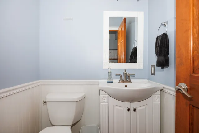 a bathroom with a toilet sink and mirror