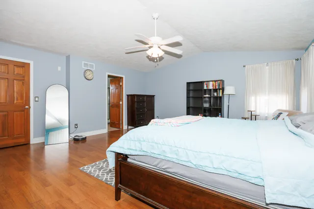 a bedroom with a bed and a dresser with mirror