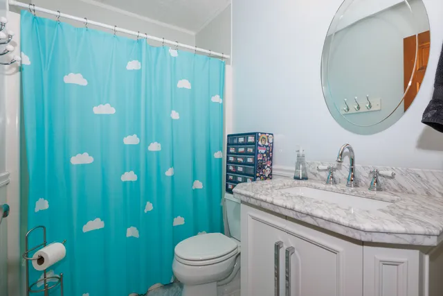 a bathroom with a granite countertop toilet sink and mirror