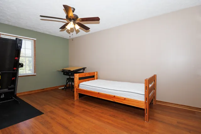 a room with wooden floor and a ceiling fan