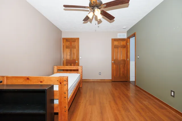 a bedroom with a bed and wooden floor