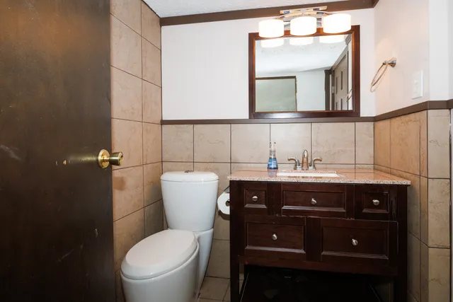 a bathroom with a toilet a sink and mirror