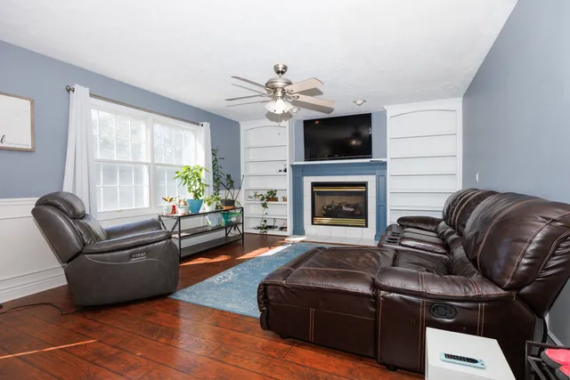 a living room with furniture a flat screen tv and a fireplace