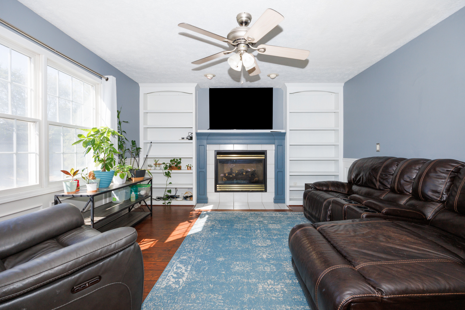 2405 Savanna Road Bloomington, IL 61705 - Photo 10 of 48 a living room with furniture a flat screen tv and a fireplace