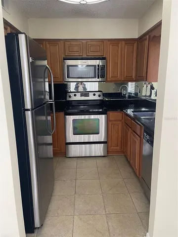 a kitchen with a refrigerator sink and cabinets