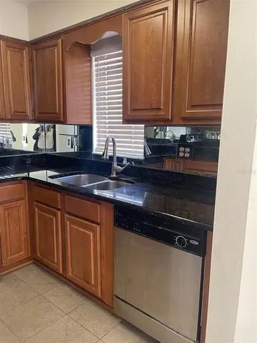 a kitchen with granite countertop cabinets and black appliances