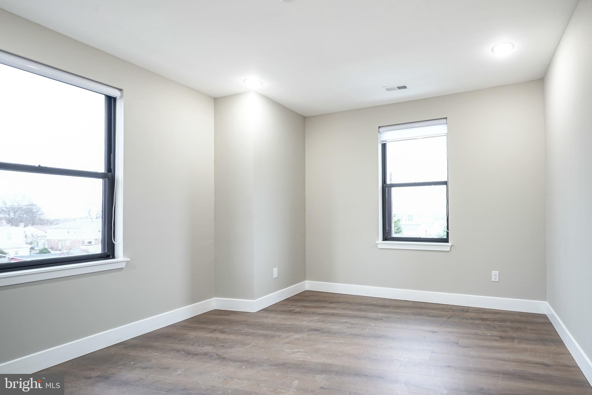 4432-00 Wingate Street, Unit 104 Philadelphia, PA 19136 - Photo 16 of 32 an empty room with wooden floor and windows