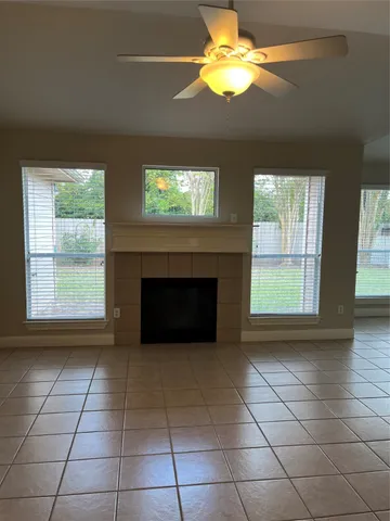 a view of an empty room with windows and fireplace