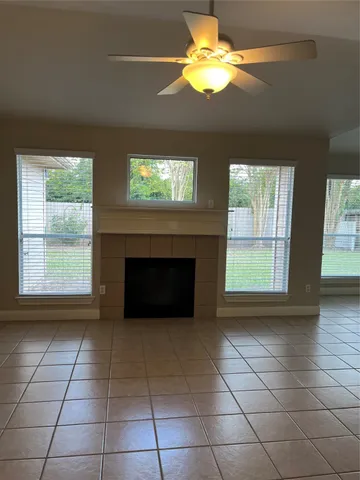 a view of an empty room with a fireplace and a window