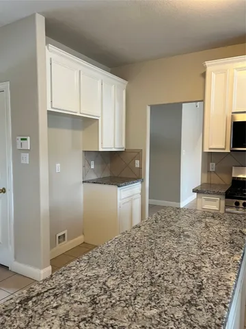 a kitchen with a refrigerator and a stove top oven