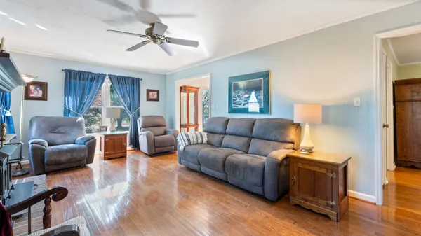 a living room with furniture ceiling fan and a window
