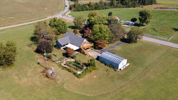 an aerial view of a house with a yard and lake view